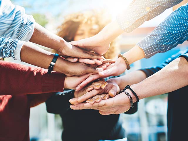 Sober young people in our support group joining hands.