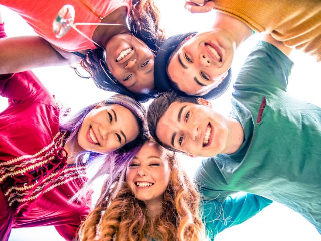 Young adults and teens in recovery joining shoulders.